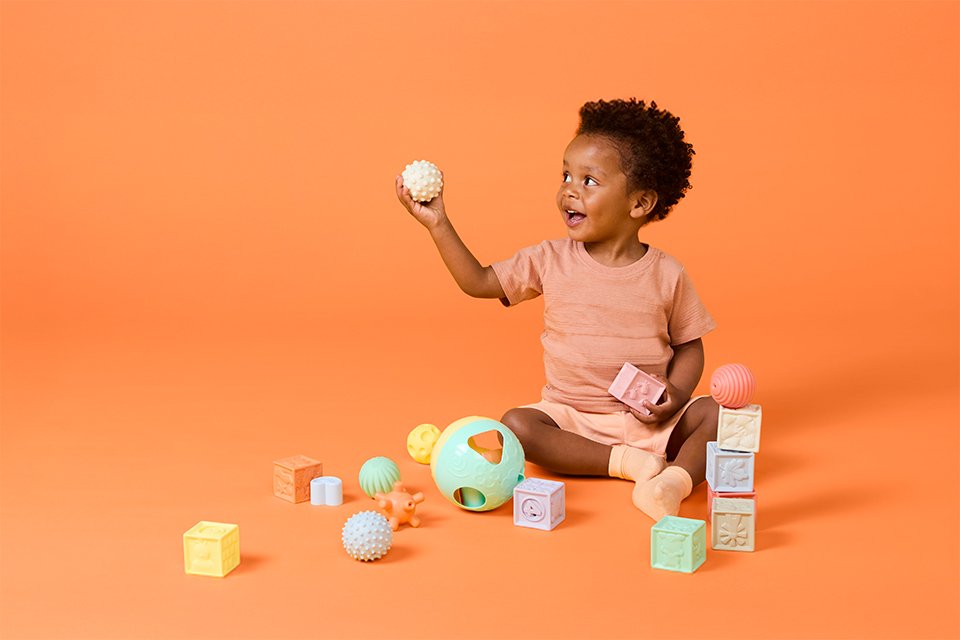 A toddler playing with one of Chad Valley's sensory toy.